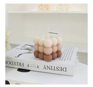 Macro detail of cube bubble candle with brown gradient on decorative books