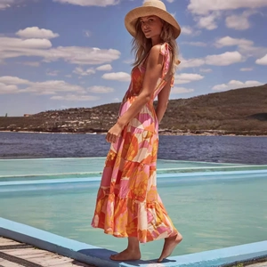Bohemian floral maxi dress with vibrant tiered skirt and spaghetti straps for summer beach vacation