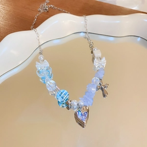 Detail of sweet beaded bracelet featuring silver bow charms and a blue rhinestone heart