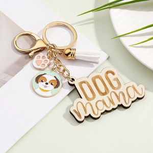 Detail of metal keychain with colorful dog head pendant, white tassel, and DOG mama wood charm