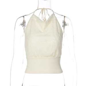Close-up of cream halter top featuring intricate lace texture and slim waist design