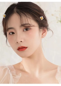 Close-up of minimalist S925 silver leaf stud earrings worn by a model in romantic style