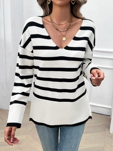 Detail view showing black and white striped long sleeve knit sweater with ribbed hem detail