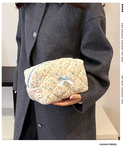 Model holding a floral quilted cotton cosmetic bag with light blue bow detail
