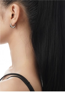 Side view of model wearing thick S925 sterling silver crescent hoop earrings in silver