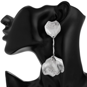Detailed view of silver flower petal earrings with brushed texture on a model
