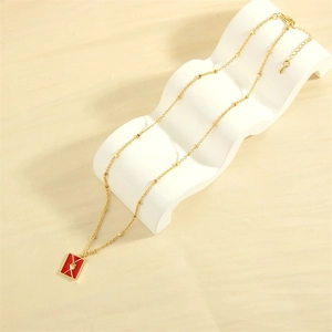 Detailed macro view of a red enamel envelope pendant with a tiny gold heart and bead chain