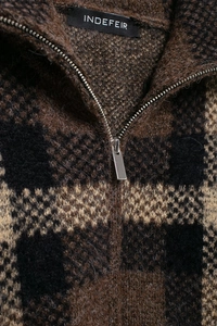 Detail of the high-quality zipper and plaid knit fabric on the bomber jacket