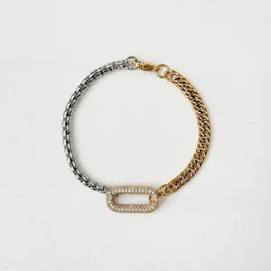 Close-up of two-tone chain bracelet with central oval pavé zircon link in gold and silver