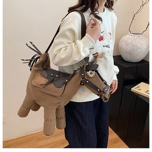 Detail of horse-shaped canvas shoulder bag with leather trim and metal rivets