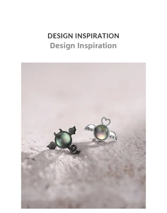 Detailed shot of asymmetric angel and demon stud earrings with iridescent shell stones
