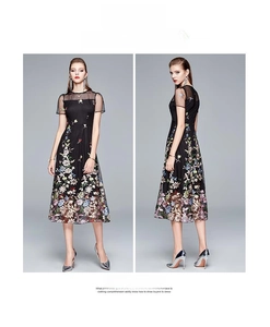 Detail of elegant black mesh dress featuring colorful floral embroidery and high waist cut