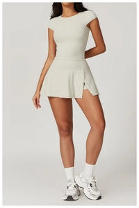 Detail view of high-waist yoga skort with side slit and matching short sleeve sports top