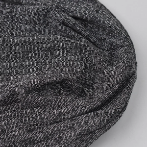 Detailed macro view of black and grey melange ribbed knit fabric texture on beanies