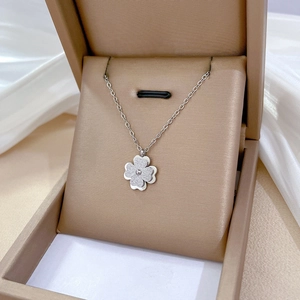 Silver frosted four-leaf clover pendant necklace on silk in a premium jewelry box