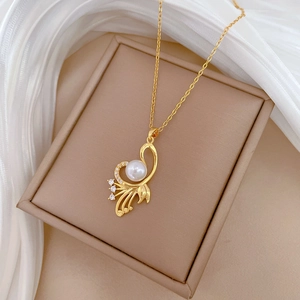 Macro detail of golden wing necklace with white pearl and crystal embellishments
