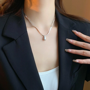Close-up of double-layer silver blade chain necklace with a minimalist teardrop pendant