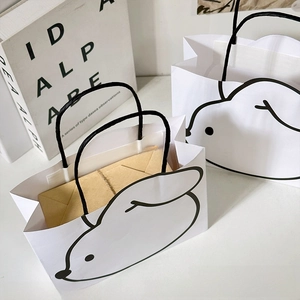 Detail view of cute rabbit print paper gift bags with black handles and minimal design