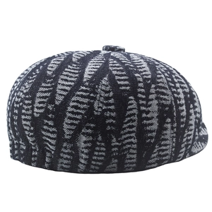 Detailed view of grey newsboy cap with woven leaf texture and vintage short brim