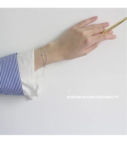 Close-up of double-layered silver beaded bracelet on wrist with elegant minimalist design