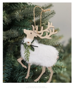 Wooden reindeer Christmas ornament with white fur and greenery hanging on a green tree