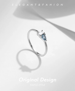 Macro detail of S925 silver ring featuring pear-cut blue stone and baguette diamond