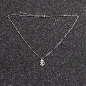 Polished stainless steel pineapple pendant necklace for women on dark glittery background
