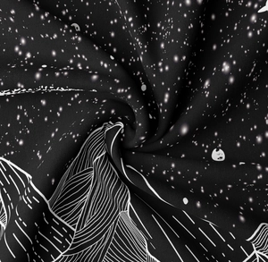 Macro shot showing detail of the starry sky and mountain print on black textile fabric
