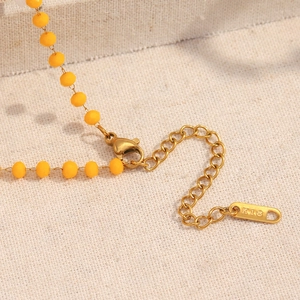 Detail of 18K gold plated extension chain with K18 tag and lobster clasp on necklace