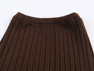 Detail of dark brown ribbed knit skirt showing textured fabric and elastic waistband