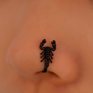 Detailed macro view of black scorpion nose clip on nostril for punk style accessory