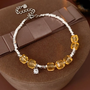 Detail of silver beaded bracelet with citrine stones and heart charm on velvet box