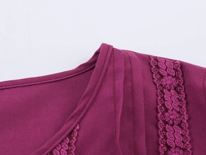 Dettaglio macro dello scollo dell'abito boho con trama viola e ricamo in pizzo