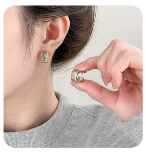Detailed view of silver square acrylic hoop earrings with a high-polished metallic finish