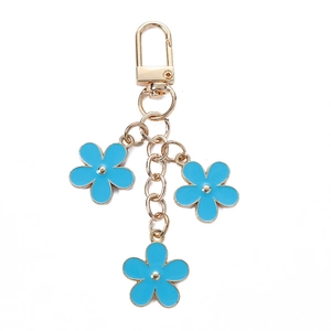 Golden keychain with light blue enamel flower charms on a clean white background