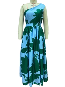 Detail of tropical leaf print and one-shoulder neckline on blue maxi dress