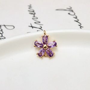 Detailed macro of a purple zircon five-petal flower pendant with gold plated settings