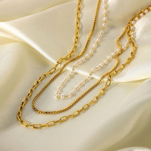 Vue macro détaillée du collier triple épaisseur en acier doré 18K avec perles et maillons