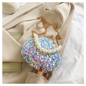 Detail of sequin seashell bag with pearl handle and iridescent blue pink finish