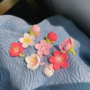 Detailed view of matte cherry blossom hair clips in pink, white and red colors