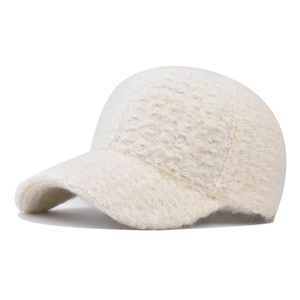 Detailed view of the thick faux shearling texture on a warm cream winter baseball cap