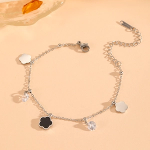 Detail of silver stainless steel flower bracelet with black pendants and clear zircons