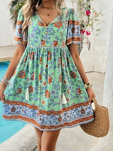 Detail of green bohemian short sleeve dress with floral print and V-neckline button design