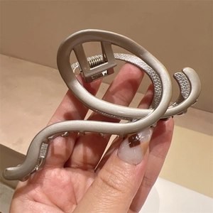 Macro shot of matte silver Y2K metal shark hair claw showing spring and non-slip teeth