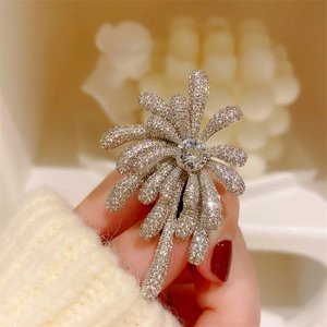 Close-up of elegant firework brooch with micro-paved zircons and center stone