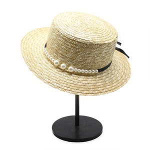 Flat top straw boater hat with elegant pearl trim and black ribbon bow detail