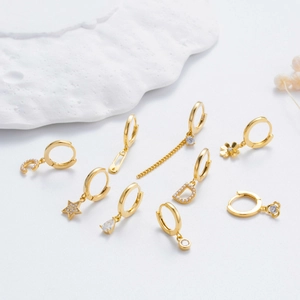 Detail of assorted gold plated hoop earrings with star moon and zircon pendants