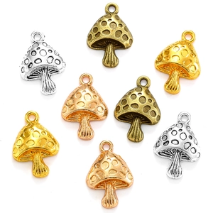Detailed view of mushroom-shaped metal charms in gold, silver, bronze and rose gold finishes