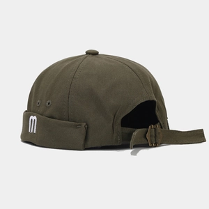 Detail of M-letter embroidery and adjustable metal buckle on olive green docker hat
