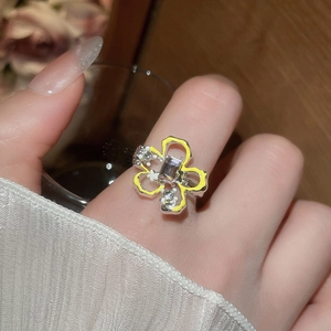 Dettaglio dell'anello a fiore con petali in smalto giallo e cristallo quadrato lucente